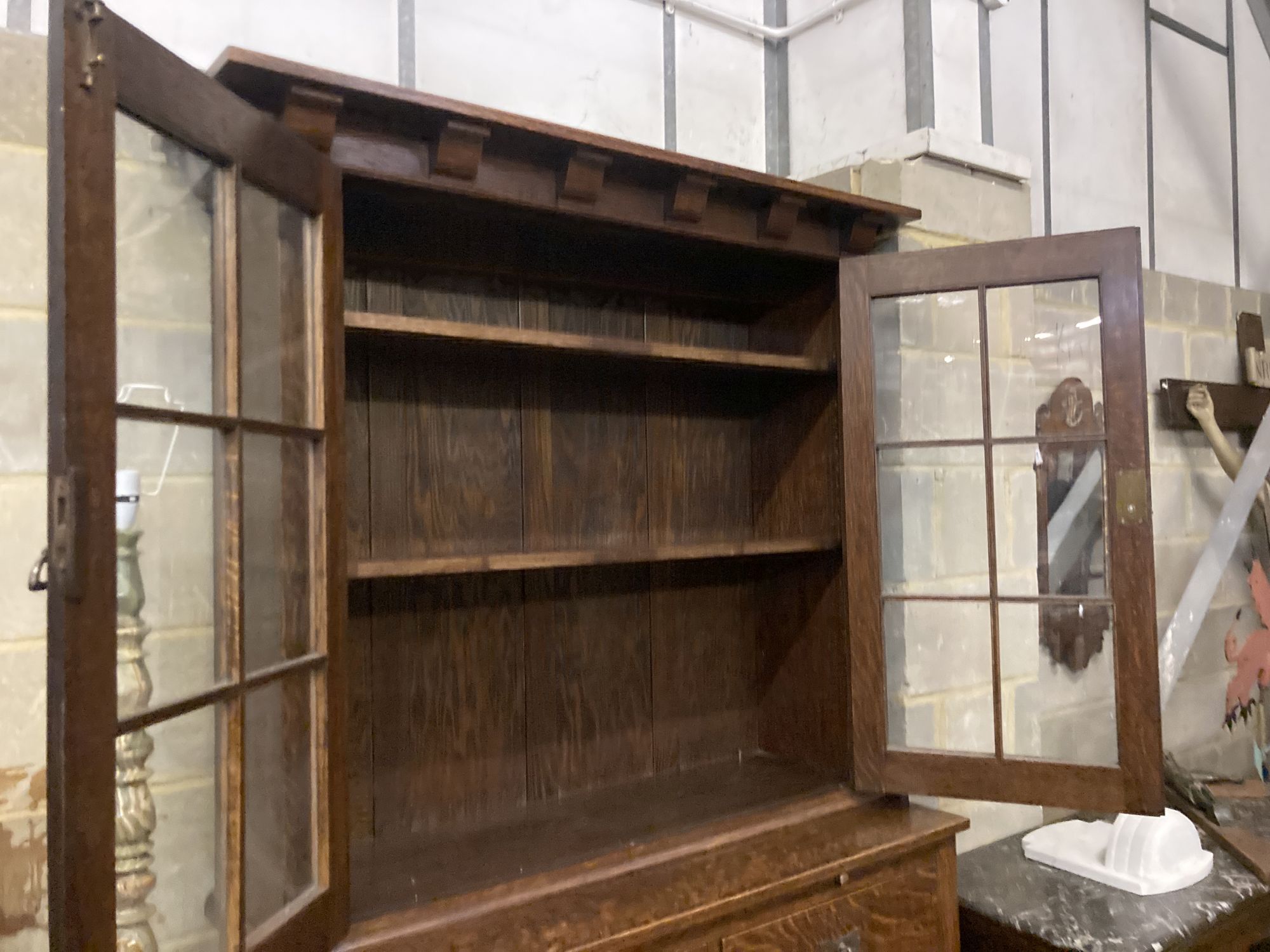 An early 20th century Arts and Crafts oak bookcase on chest, width 114cm, depth 48cm, height 208cm